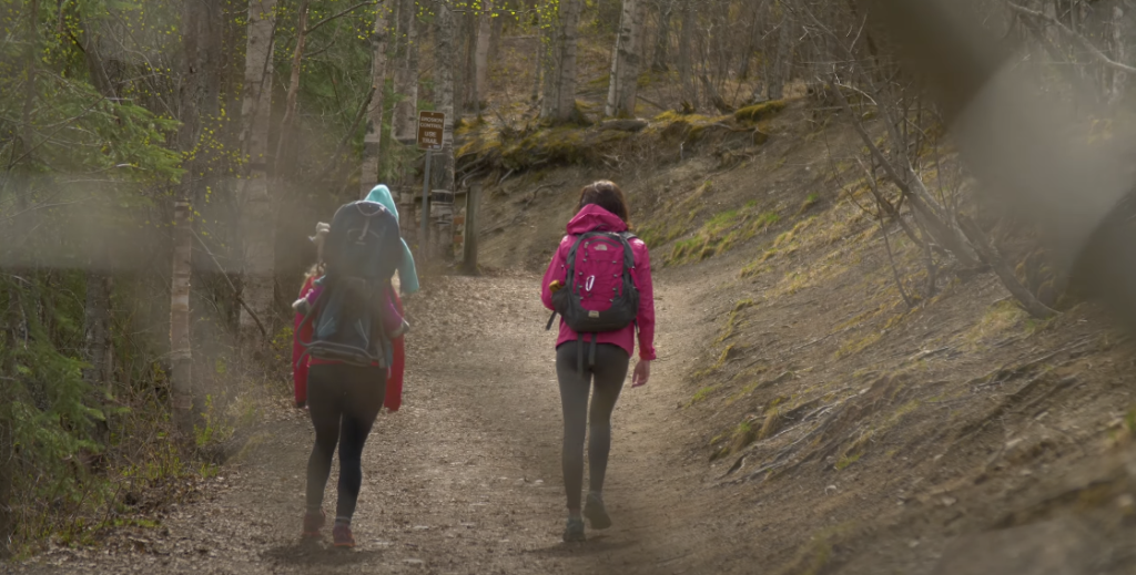 Three individuals hiking on a trail.