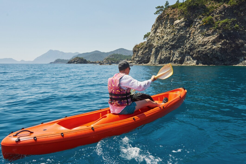 Man kayaking in a river with a life vest